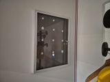 a picture of a bathroom with a mirror and a yellow chair
