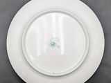 white plate with a green design on it sitting on a table