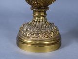 a gold vase with a face on it sitting on a table