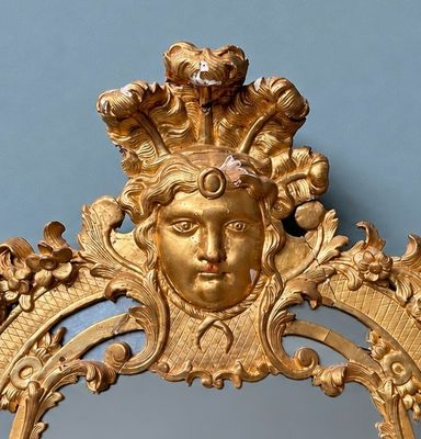un miroir doré avec un visage au milieu
