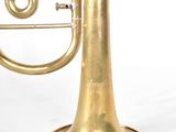 an old brass trumpet sitting on top of a white surface