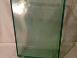 un vase en verre vert muni d'un couvercle, posé sur une table