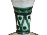 a green and white vase sitting on top of a table