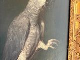 painting of a parrot perched on a branch in a gold frame
