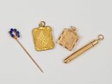 trois objets plaqués or, à savoir une aiguille, un livre et un marque-page