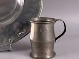 a silver plate and a silver cup next to a silver plate