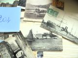 une pile de vieilles cartes postales posée sur une table, avec un petit mot dessus