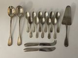 a lot of silver spoons and knives on the table