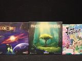 four board games are lined up on a black surface