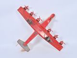 a red toy airplane that is flying in the sky