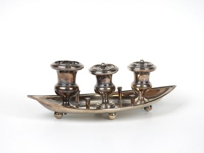 un plateau en argent avec trois bougies et un bateau