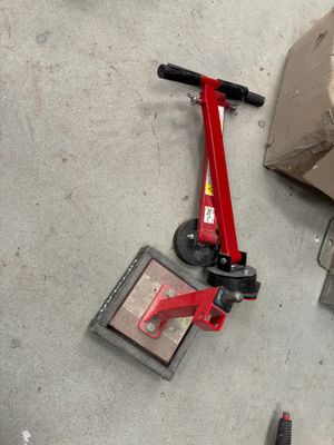 un scooter rouge posé par terre à côté d'une boîte