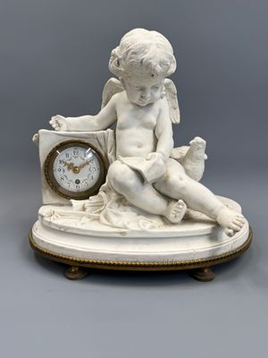 a small statue of a child sitting on a clock