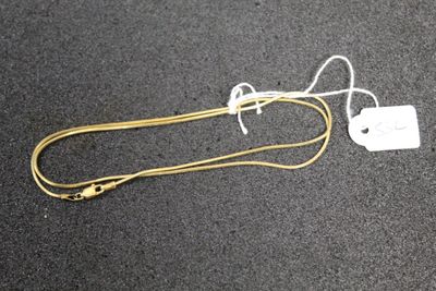 a white tag attached to a yellow cord on the ground