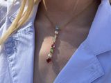 a close up of a woman wearing a white shirt and a gold necklace