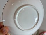 a person holding a plate in their hand over some plates