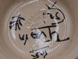 a brown bowl with writing on it with a blue rim