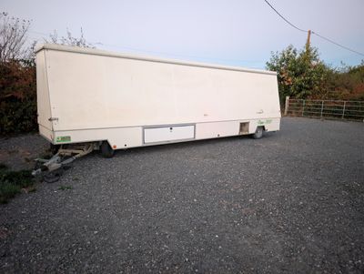 a white trailer that is parked on the side of the road