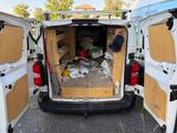 the back of a van with the door open and a bunch of items in the back
