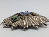 an image of a broochle with a blue stone in the center