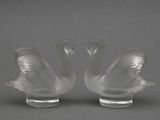 paire de figurines de cygnes en verre transparent sur un socle transparent