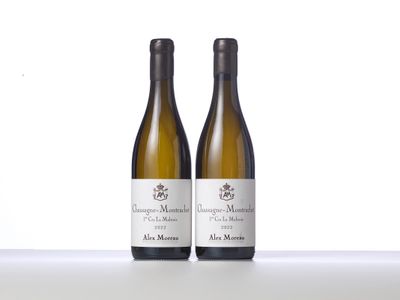 two bottles of white wine sitting on top of a table