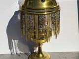 a gold lamp with a chain hanging from the top of it