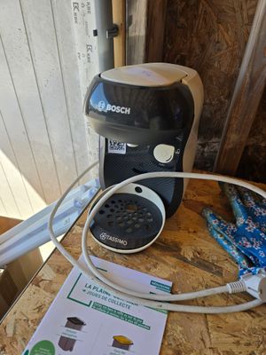 a coffee maker on a table next to a box of ice cream