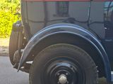 a old black car parked on the side of the road