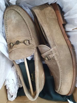 une paire de mocassins pour homme dans une boîte posée sur une table