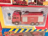 a red fire truck in the box next to other toys