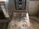 a picture of a commercial kitchen with four pans of food on the counter