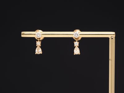 une paire de boucles d'oreilles en diamant sur un support plaqué or