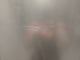a person that is standing behind a frosted glass door