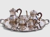 a silver tray with a silver tea set on it