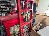 un établi rouge dans un garage rempli d'outils