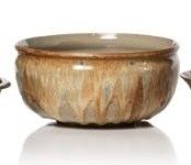 a bowl and two spoons sitting on a white surface