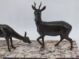 statue of two antelope on a marble base with a white background