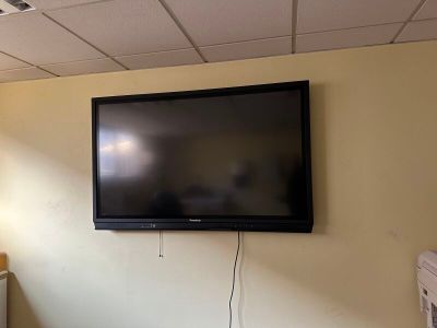 un téléviseur à écran plat fixé au mur d'une pièce