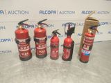 four fire extinguisors are lined up in front of a wall
