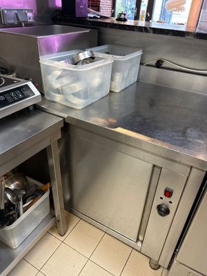 plan de travail en acier inoxydable dans une cuisine commerciale avec des casseroles et des poêles dessus