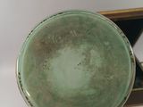 a person holding a green bowl in their hand