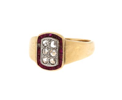 gros plan d'une bague en or avec un rubis et un diamant au centre