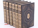 cinq livres sont empilés les uns sur les autres sur une surface blanche