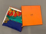 une boîte orange contenant une écharpe bleue et orange