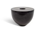 a black vase that is sitting on a white surface