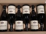 six bouteilles de vin dans un carton sur une table