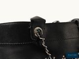the back of a black purse with a chain hanging from it