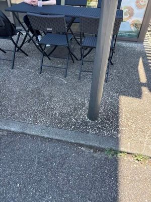 a woman sitting at a table outside of a restaurant