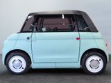 a small blue car with a black top parked in a parking lot